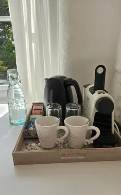 a tray with three coffee cups and a toaster at Primrose Cottage in Helston