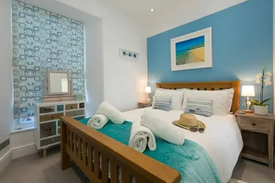 a bedroom with a large bed with towels on it at Sea Salt sea views parking in St Ives