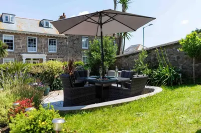 a table and chairs with an umbrella in a yard at Sea Salt sea views parking in St Ives