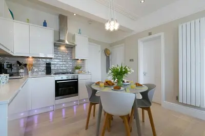 a kitchen with a table and chairs in a room at Sea Salt sea views parking in St Ives