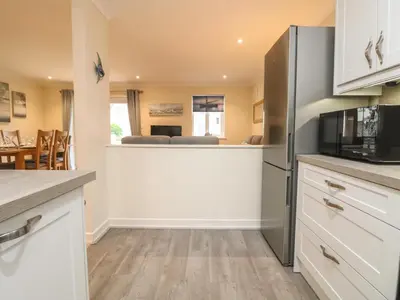 a kitchen with a refrigerator and a dining room at Manuka in Falmouth