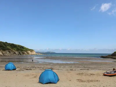 two tents on a sandy beach with the ocean at Manuka in Falmouth