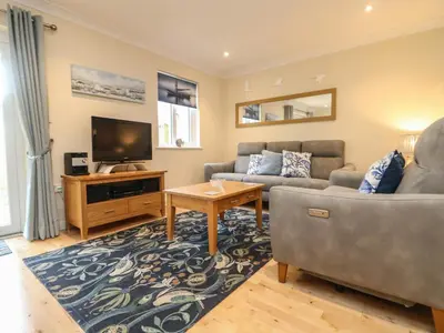 a living room with a couch and a tv at Manuka in Falmouth