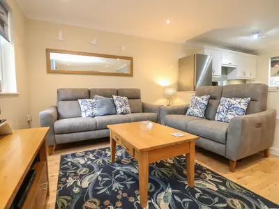 a living room with a couch and a table at Manuka in Falmouth