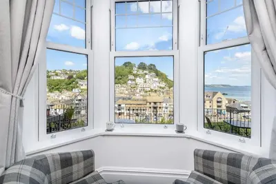 a living room with two chairs and two windows at Rame in Looe