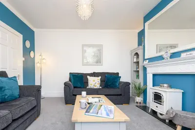 a living room with two couches and a fireplace at Rame in Looe