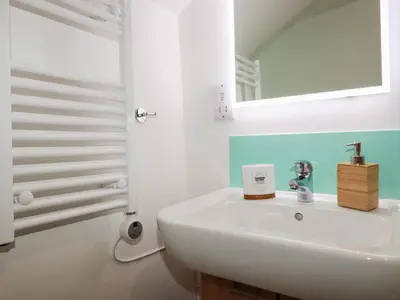 a bathroom with a white sink and a mirror at Harbour Light in Boscastle
