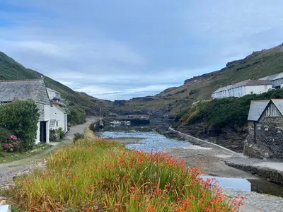 a river in a village with houses and mountains at Harbour Light in Boscastle