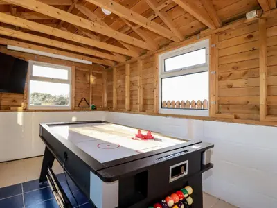 a stove in a room with wooden walls and windows at Seacroft in Newquay