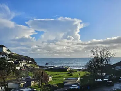 a view of the ocean from a town with houses at Pet Friendly Sea view Villa Millendreath Looe in Looe