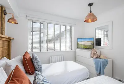 a bedroom with two beds and a teddy bear at 3 Europa Court in Mawgan Porth in Mawgan Porth