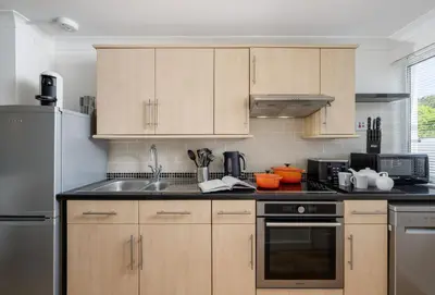 a kitchen with wooden cabinets and stainless steel appliances at 3 Europa Court in Mawgan Porth in Mawgan Porth