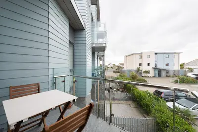 a balcony with two benches and a table at 41 Tre Lowen in Fistral, Newquay in Newquay