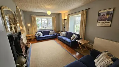 a living room with blue couches and a fireplace at Corner Cottage in Saint Mawes