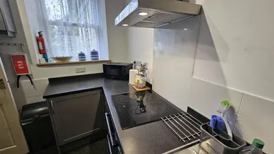 a small kitchen with a sink and a stove at Corner Cottage in Saint Mawes