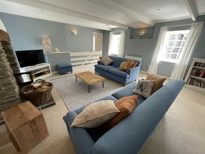 a living room with a blue couch and a tv at Crugsillick Court in Veryan