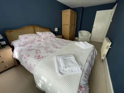 a bedroom with a large bed and a blue wall at Crugsillick Court in Veryan