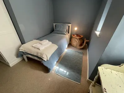 a small bedroom with a bed and a table at Crugsillick Court in Veryan