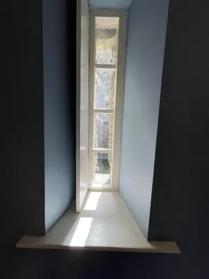 an empty room with a window in a white wall at Crugsillick Court in Veryan