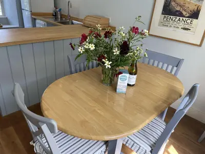 a wooden table with a vase of flowers on it at Crugsillick Court in Veryan