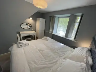 a bedroom with a large white bed with two towels on it at Crugsillick Court in Veryan