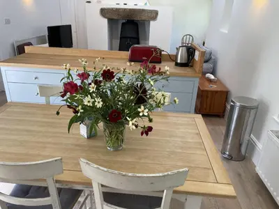 a vase of flowers sitting on a wooden table at Crugsillick Studio in Veryan