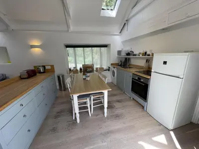 a kitchen with a wooden table and a white refrigerator at Crugsillick Studio in Veryan
