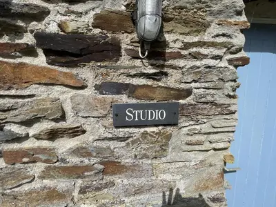 a street sign on the side of a stone wall at Crugsillick Studio in Veryan