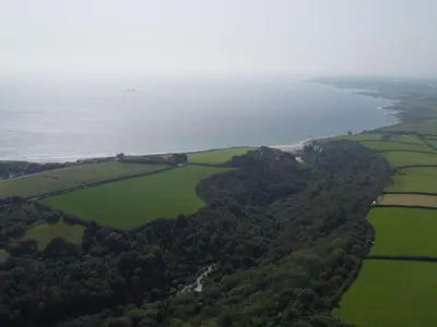 an aerial view of the ocean and green fields at Crugsillick Studio in Veryan