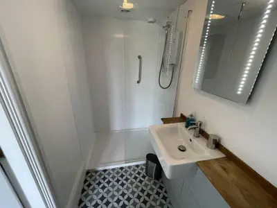 a white bathroom with a sink and a shower at Crugsillick Studio in Veryan