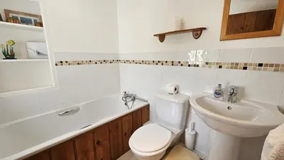 a bathroom with a toilet and a sink at Hillside Cottage in Porthscatho