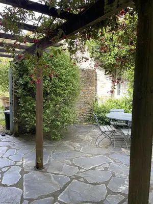 a stone patio with a table and a bench at Little Crugsillick in Veryan