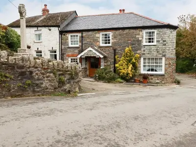 an old stone house on the side of the road at Mill Cottage in Liskeard