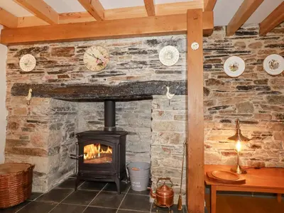 a brick wall with a stove in a room at Mill Cottage in Liskeard