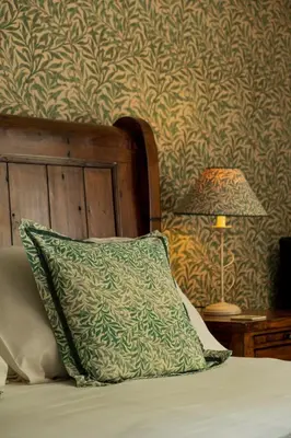 a pillow sitting on a bed next to a lamp at The Old Mill House in Padstow