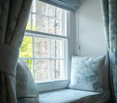 a window seat with a pillow in front of a window at The Old Mill House in Padstow