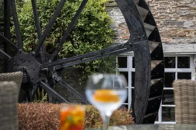 a glass of wine sitting on a table at The Old Mill House in Padstow