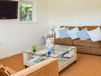 a living room with a couch and a glass table at Top Deck - Cottage in Gorran Haven