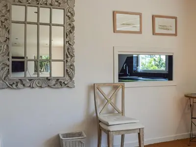 a mirror and a chair in a room at Top Deck - Cottage in Gorran Haven