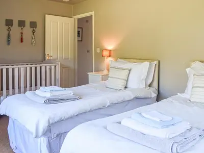 two beds with towels on top of them in a room at Top Deck - Cottage in Gorran Haven