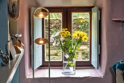 a vase of flowers sitting on a window sill at Finest Retreats - Fishermans Cottage in Tintagel