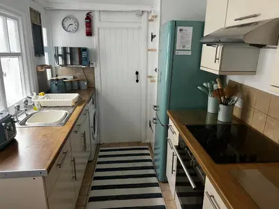 a small kitchen with a sink and a refrigerator at Waves End in St Austell