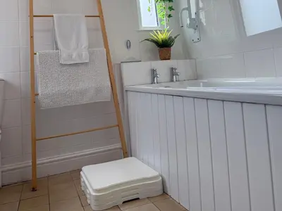 a white bathroom with a sink and a toilet at Waves End in St Austell