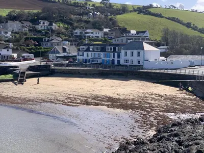 a view of a beach with houses and buildings at Waves End in St Austell