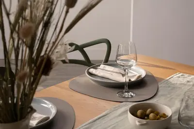 a table with a glass of wine and a bowl of food at Estuary Watch in St Ives