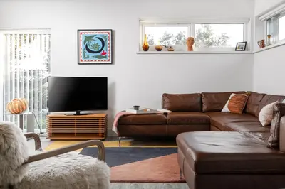a living room with a couch and a flat screen tv at Estuary Watch in St Ives