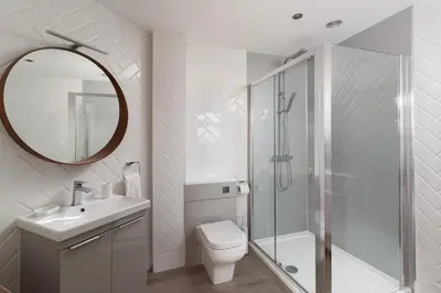 a bathroom with a toilet and a shower and a sink at Estuary Watch in St Ives