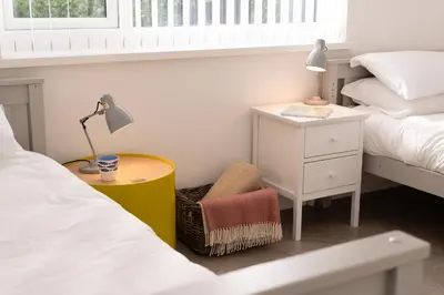 a bedroom with a bed and a table with a lamp at Estuary Watch in St Ives