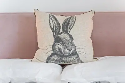 a pillow with a drawing of a rabbit on a bed at Delightful Family Getaway Cornwall in Mawnan Smith