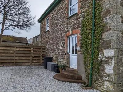 a brick house with a white door and a fence at Delightful Family Getaway Cornwall in Mawnan Smith
